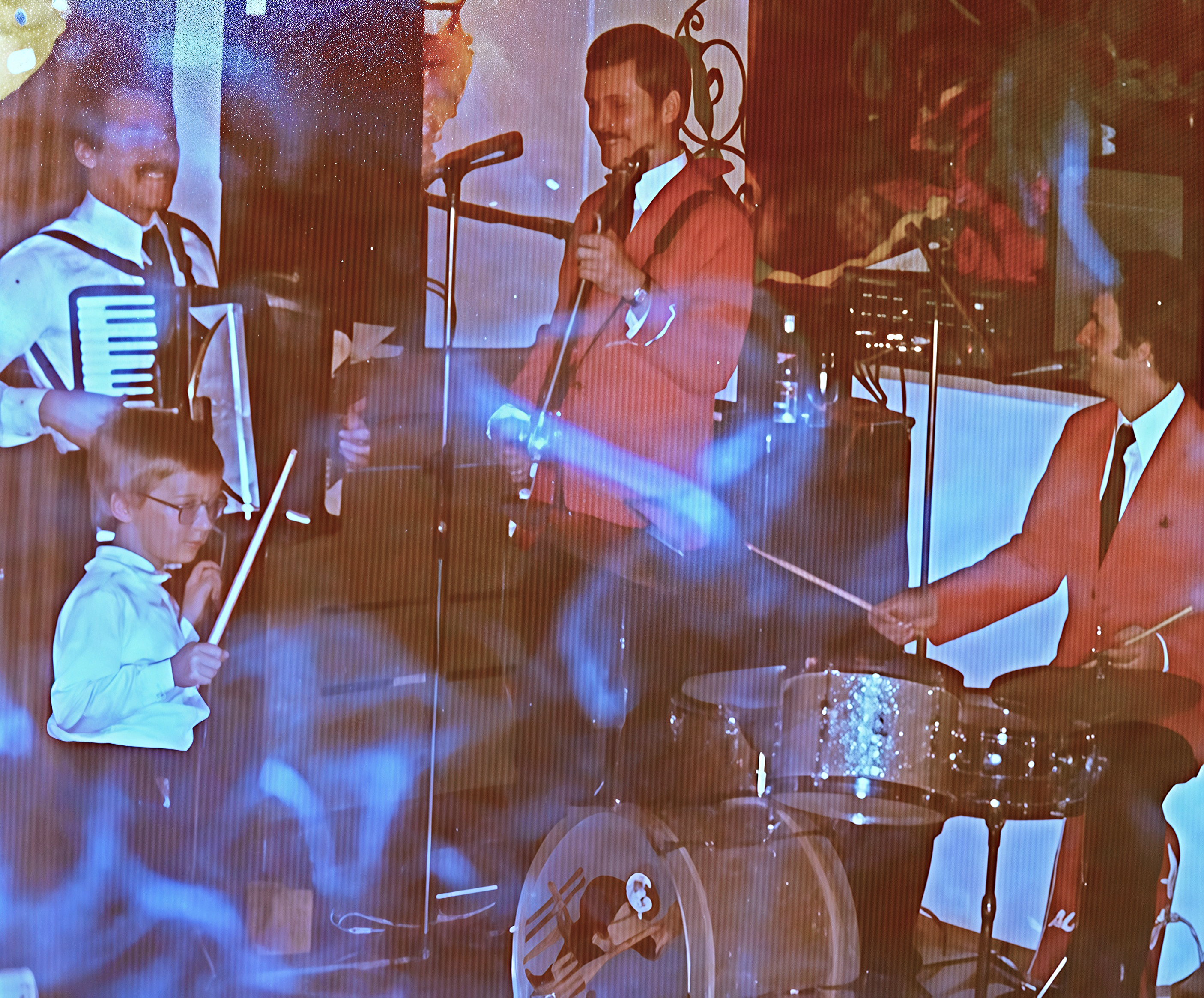 Kevin Forbes als Kind mit Drumstick vor einer Live-Band