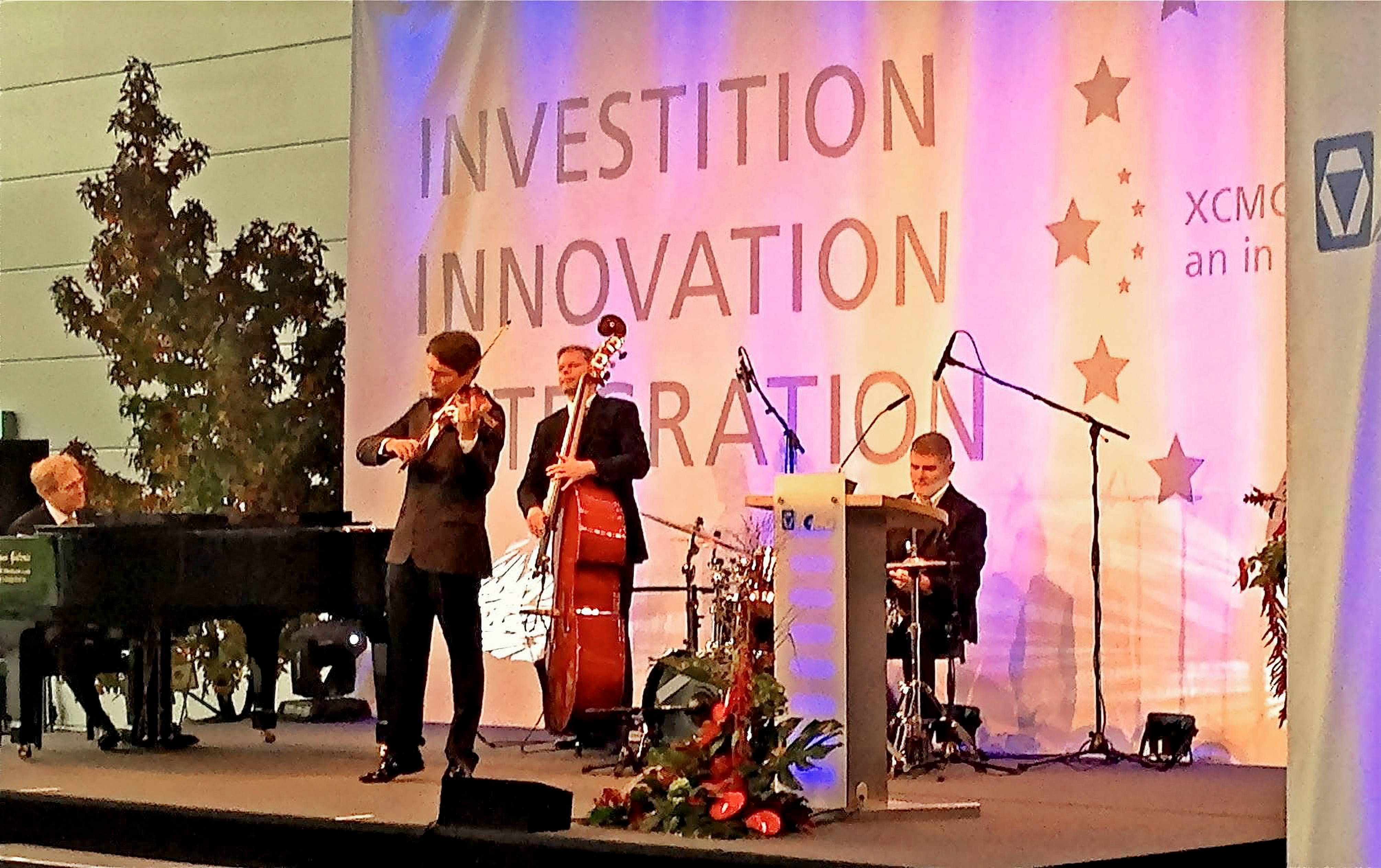 Kevin Forbes mit Violine, Kontrabass und Schlagzeug bei der Er&ouml;ffnung von XCMG Europe